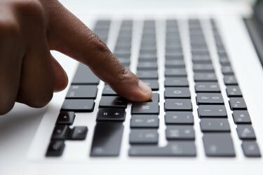 dito nero digitando sulla tastiera del computer