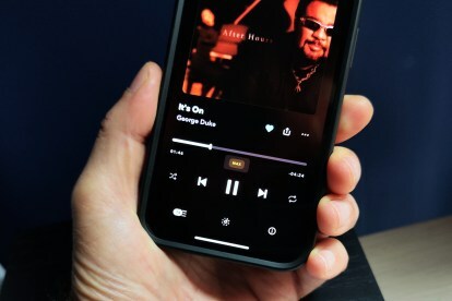 Aplicativo Tidal para iOS em um iPhone 14 mostrando a tela em reprodução com faixa de qualidade máxima.