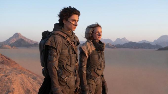 Timothee Chalamet ir Rebecca Ferguson žiūri į kopų dykumą.