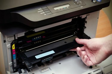 La mano del hombre pone tóner en la impresora
