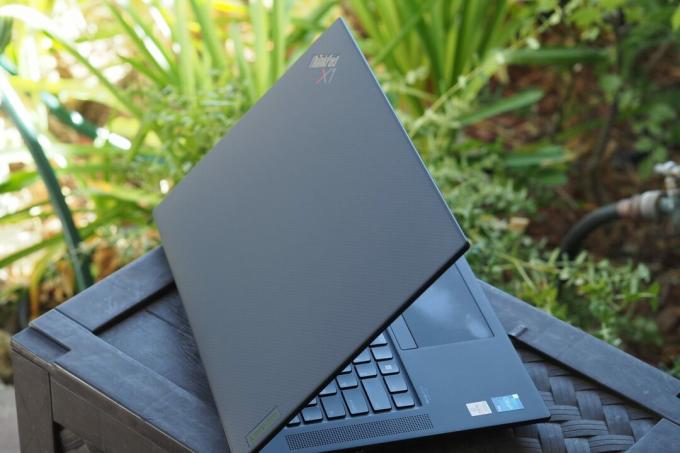Visão traseira do Lenovo ThinkPad X1 Extreme Gen 5 mostrando logotipos e tampa de fibra de carbono.