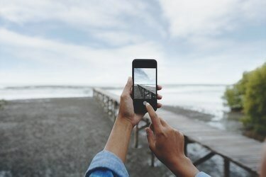 풍경 사진을 찍는 스마트 폰을 사용하여 손에 선택적 초점