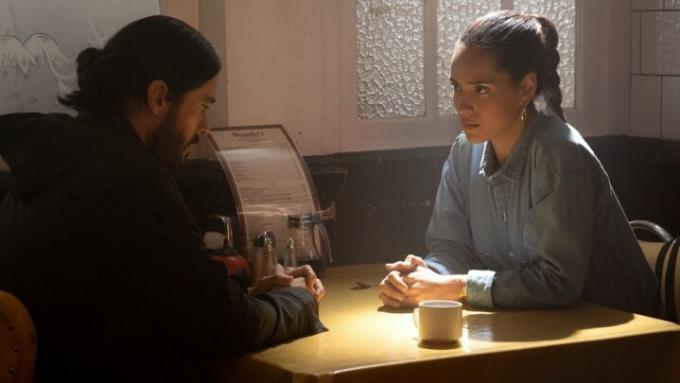 Jared Leto og Adria Arjona sitter ved et bord i en scene fra Morbius.
