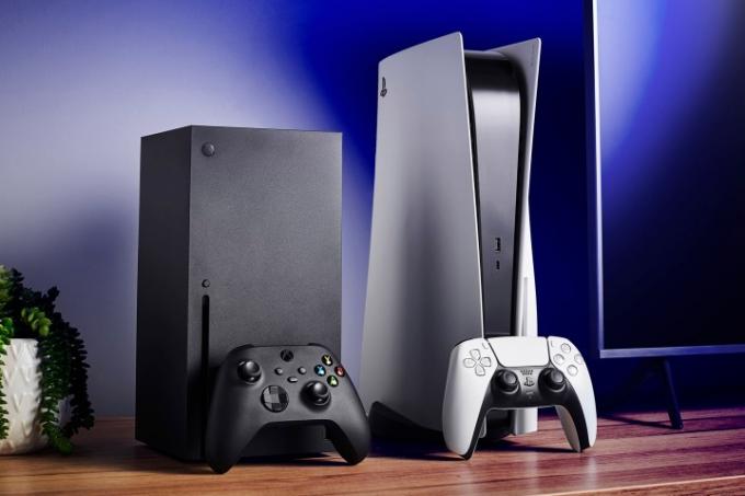 Sala de estar con consolas de videojuegos domésticas Microsoft Xbox Series X (L) y Sony PlayStation 5 junto con un televisor y una barra de sonido.