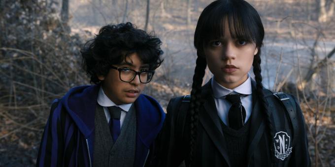 Moosa Mostafa e Jenna Ortega fissano la telecamera in una scena di mercoledì.