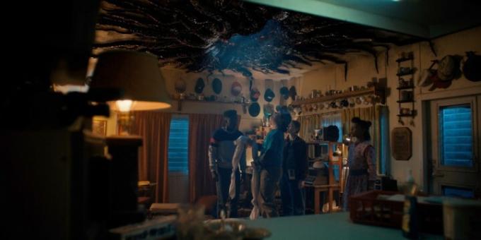 Los personajes de Stranger Things miran hacia un portal en el techo de una habitación.