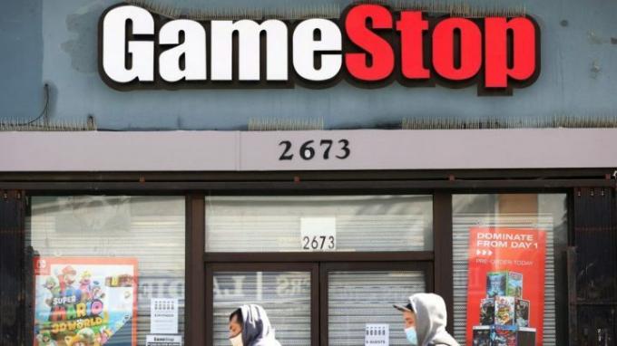 Pembeli berjalan di depan etalase GameStop.