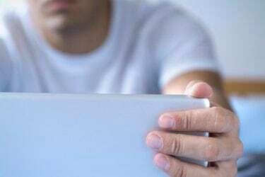 Detailný záber na mužské prsty otvárajúce laptop