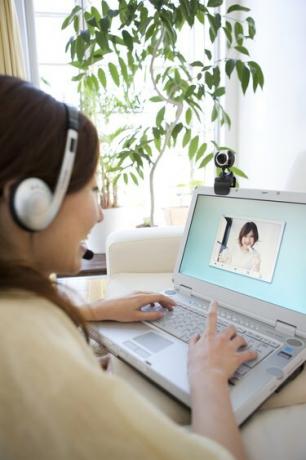 Ung kvinne har en videokonferanse på den bærbare datamaskinen