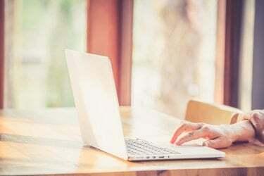 Mano mujer escribiendo teclado de computadora portátil.