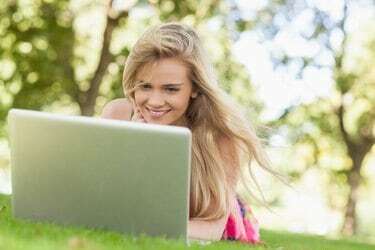 Šťastná blondýnka pracující se svým notebookem