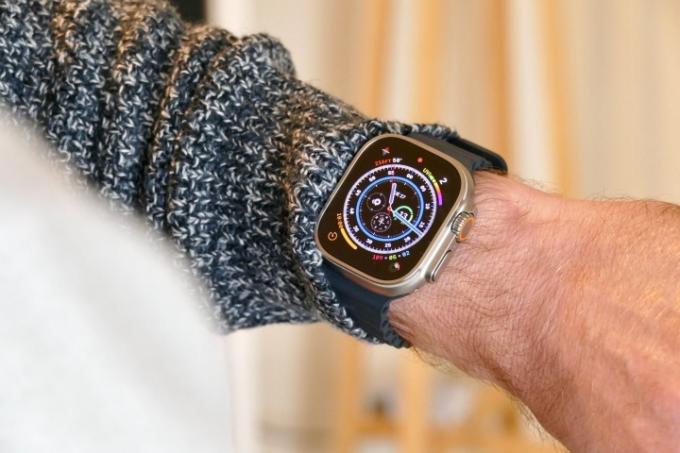 Apple Watch Ultra s številčnico Wayfinder na moškem zapestju.