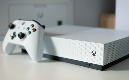 Xbox Series S op een witte tafel geplaatst met de controller er net voor