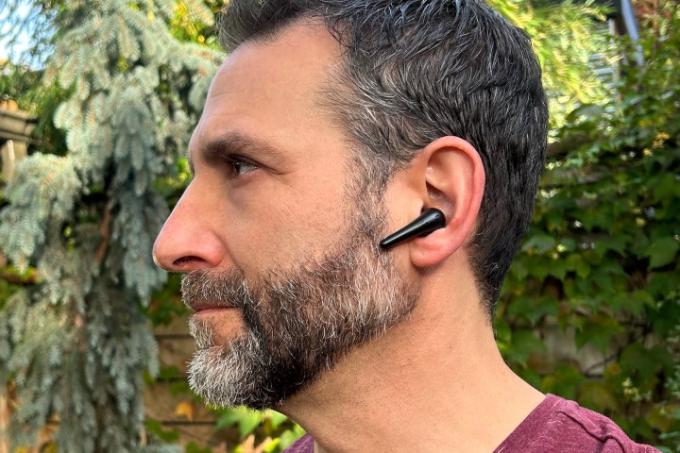 Moški, ki nosi brezžične ušesne slušalke 1More Aero.