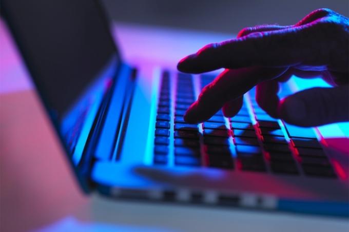Persona escribiendo en el teclado de una computadora.