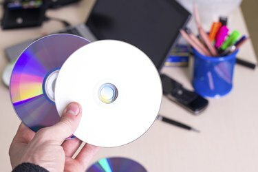 hånd, der holder hvid tom cd-dvd-disk