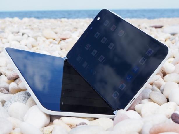 小石の上に置かれた Microsoft Surface Dup 折りたたみ式スマートフォン。