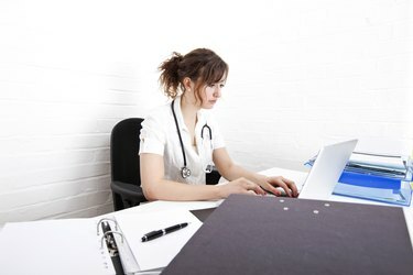 Jeune femme médecin utilisant un ordinateur portable au bureau en clinique