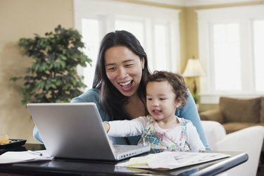 Matka a dieťa zmiešané rasy pri pohľade na laptop