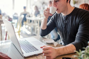 Jonge hipster man die zijn koffie drinkt in een café-bar