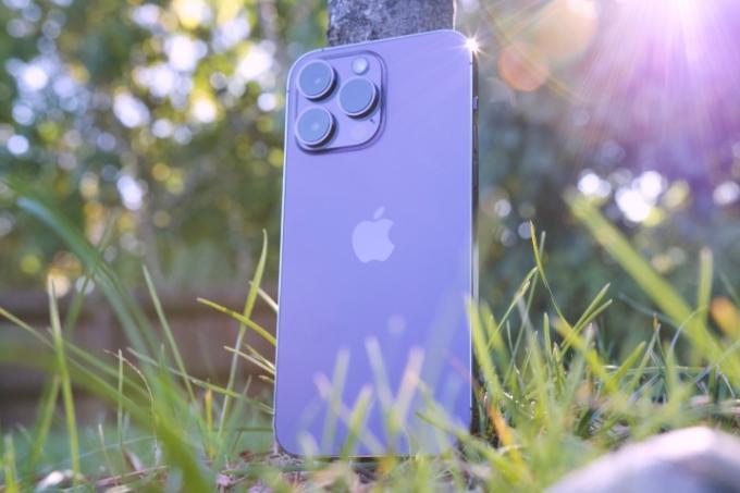 iPhone 14 Pro Max seisoo puuta vasten.