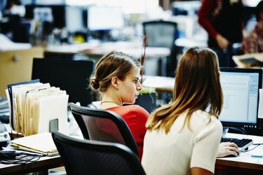 Due donne d'affari sedute che lavorano al computer