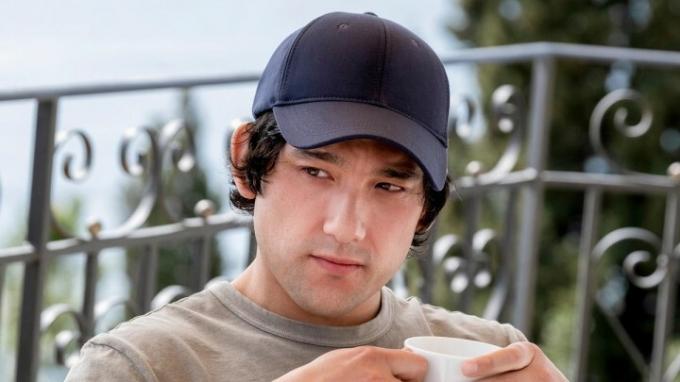 Ethan bär en hatt och smuttar på sitt kaffe i The White Lotus.