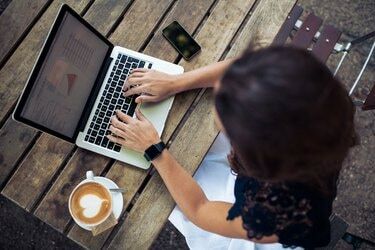 Wanita menggunakan laptopnya di kedai kopi