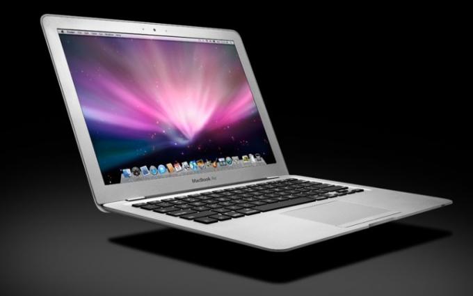 Een MacBook Air die boven een zwart oppervlak zweeft, met het OS X Snow Leopard-besturingssysteem op het scherm.