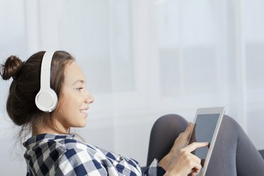 Mulher com fones de ouvido ouve música no tablet PC