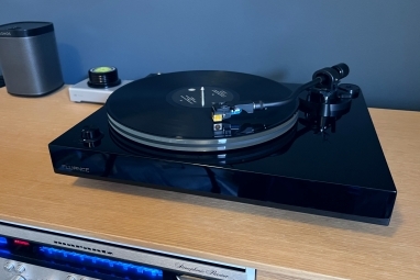 Gramofon Fluance RT85N w kolorze fortepianowej czerni na jednostce multimedialnej.