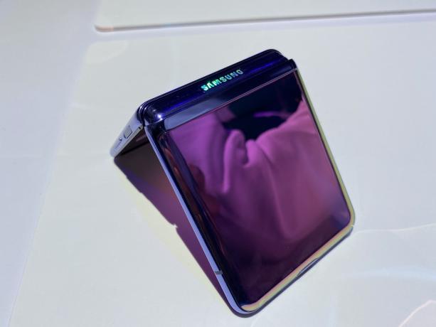 O Galaxy Z Flip virado para baixo sobre uma mesa, meio dobrado.
