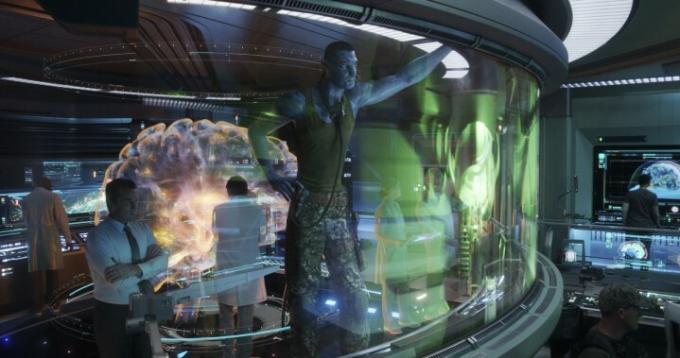 Um grande Na'vi fica ao lado de um humano em uma sala de controle em uma cena de Avatar: The Way of Water.