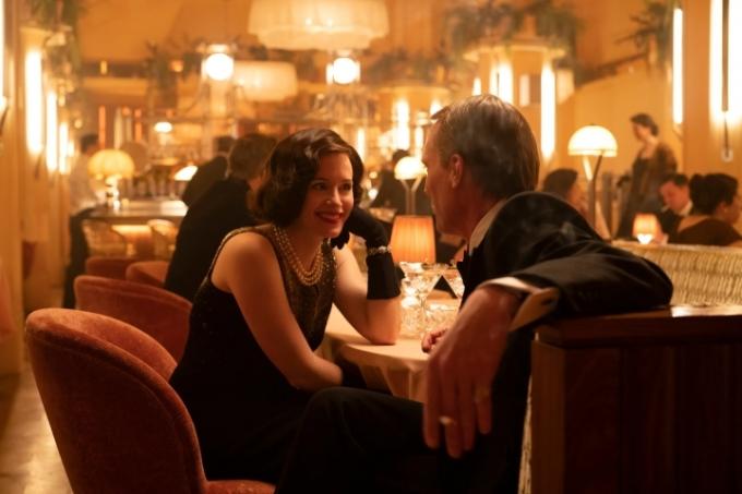 Claire Foy sidder ved et middagsbord med Paul Bettany i A Very British Scandal.
