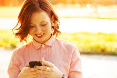 Mujer joven con un teléfono inteligente al aire libre