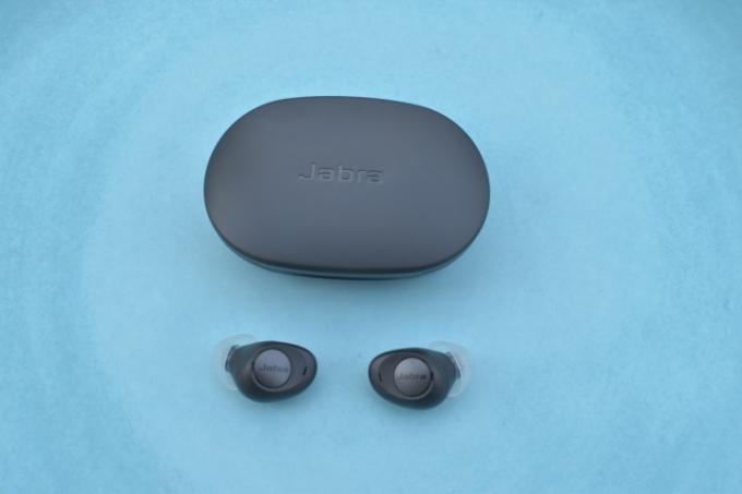 Słuchawki douszne Jabra Enhance Plus z etui na niebieskim tle.