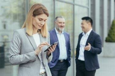 Een mooie en succesvolle zakenvrouw gebruikt de telefoon buiten het kantoor