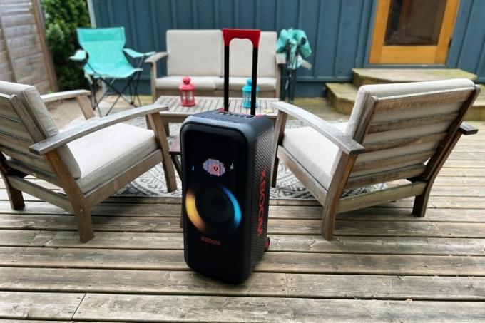 El parlante portátil para fiestas LG XBoom XL7 con su asa extendida en una terraza al aire libre.