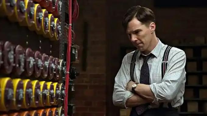 Benedict Cumberatch olhando para uma linha de códigos na parede em uma cena de O Jogo da Imitação.
