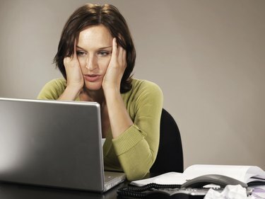 mujer se sentar, en, computador portatil, codos, en, escritorio, tenencia, cabeza en manos