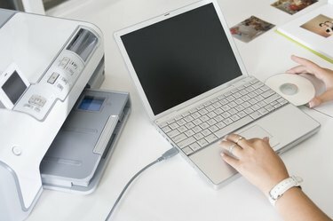 Руки с портативным компьютером и принтером