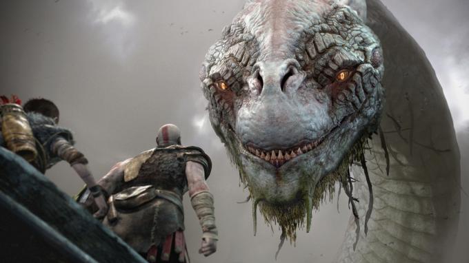 God of War-recensie | Kratos en Atreus in een boot kijken omhoog naar een gigantisch hydra-achtig beest