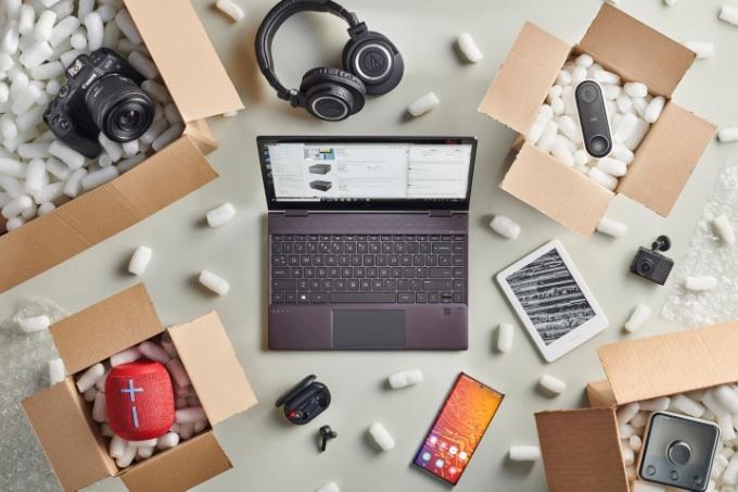 „Amazon“ nešiojamas kompiuteris, apsuptas techninės įrangos dėžėmis.