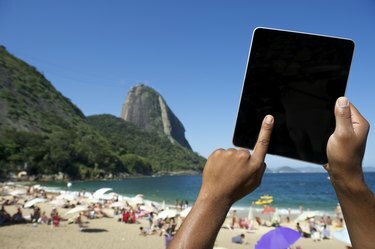 Brazílske ruky používajúce tablet v Sugarloaf Rio de Janeiro Brazília