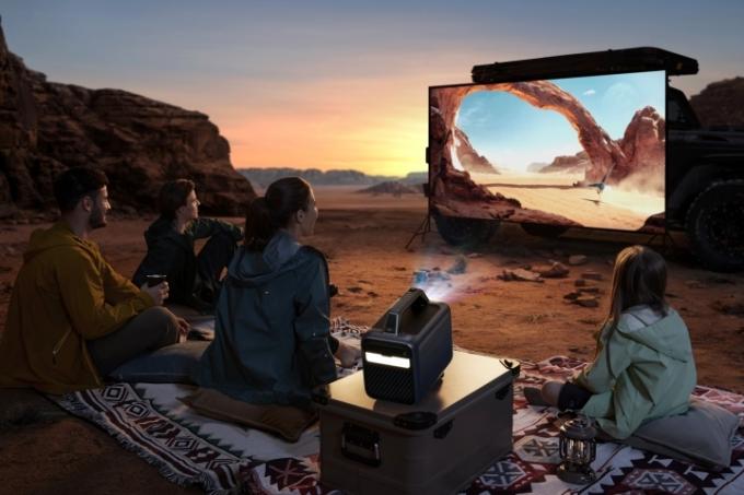 Ο εξωτερικός προβολέας Anker Nebula Mars 3 που δείχνει μια ταινία σε μια οθόνη στην έρημο.