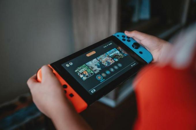 Persoană care deține Nintendo Switch și se uită la ecranul de pornire.