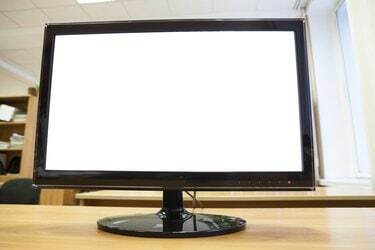 Monitor preto com tela isolada em cima de uma mesa de escritório
