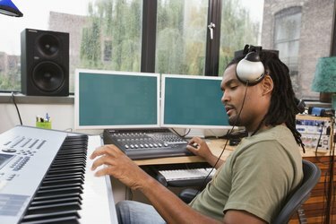 Üretim stüdyosunda şarkı kaydeden adam