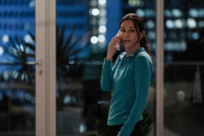 Gale Weathers contesta su teléfono en su apartamento en Scream 6.