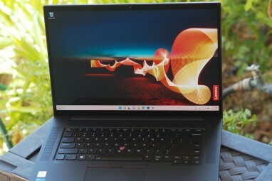 녹색 풍경을 배경으로 외부에 있는 ThinkPad X1 Extreme Gen 5.